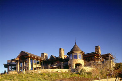 Photo of an expansive contemporary three-storey exterior in Salt Lake City with stone veneer.