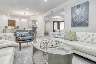 Photo of a mid-sized contemporary open concept living room in Miami with white walls, light hardwood floors, a wall-mounted tv, beige floor and vaulted.