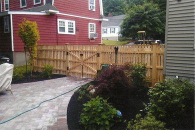Photo of a mid-sized craftsman partial sun backyard brick driveway in Boston.
