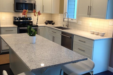 Eat-in kitchen - mid-sized contemporary u-shaped eat-in kitchen idea in Wichita with an undermount sink, recessed-panel cabinets, white cabinets, white backsplash, subway tile backsplash, stainless steel appliances, an island and white countertops