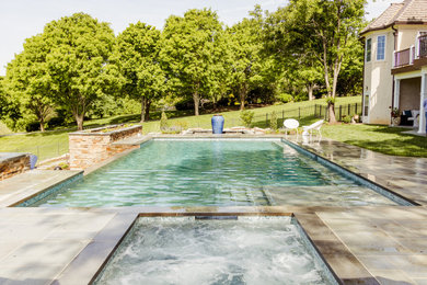 Example of a large classic backyard stone and rectangular infinity pool landscaping design in Wilmington