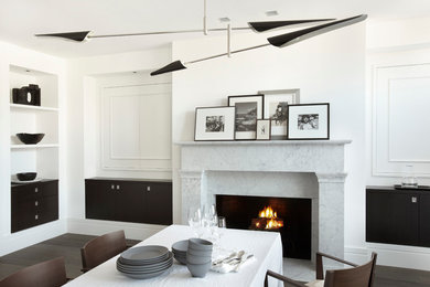Inspiration for a contemporary dining room in San Francisco with white walls, dark hardwood floors and a standard fireplace.