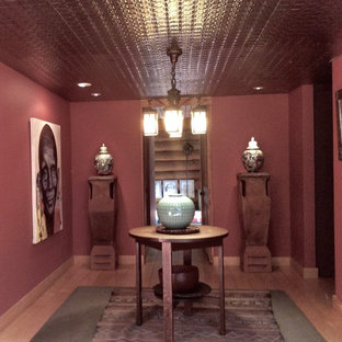 Inredning av en eklektisk mellanstor foajé, med röda väggar, ljust trägolv, en enkeldörr och en brun dörr