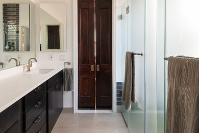 Inspiration for a mid-sized contemporary medium tone wood floor and beige floor kitchen remodel in DC Metro with a drop-in sink, flat-panel cabinets, black cabinets, soapstone countertops, white backsplash, stone slab backsplash and stainless steel appliances