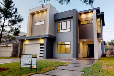 Inspiration for a large contemporary gray two-story house exterior remodel in Houston with a metal roof and a black roof