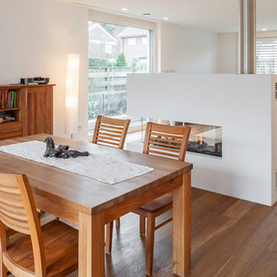 ケルンの中サイズの北欧風 LDKの画像 (白い壁、両方向型暖炉、漆喰の暖炉まわり、茶色い床、無垢フローリング)