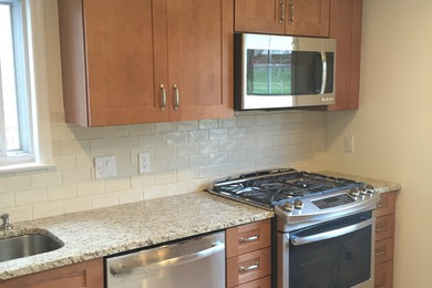 Enclosed kitchen - small contemporary l-shaped ceramic tile enclosed kitchen idea in New York with an undermount sink, shaker cabinets, light wood cabinets, granite countertops, beige backsplash, subway tile backsplash, stainless steel appliances and no island