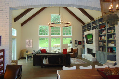Example of a large trendy open concept dark wood floor and brown floor family room design in Kansas City with white walls, a standard fireplace, a brick fireplace and a wall-mounted tv