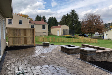 Inspiration for a mid-sized contemporary backyard concrete paver patio remodel in New York with a fire pit and no cover