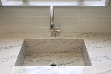 Mid-sized trendy l-shaped vinyl floor and multicolored floor open concept kitchen photo in Philadelphia with an undermount sink, shaker cabinets, white cabinets, quartzite countertops, blue backsplash, glass tile backsplash, an island and multicolored countertops