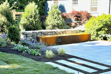 Photo of a large traditional full sun backyard stone and wood fence water fountain landscape in Boston.