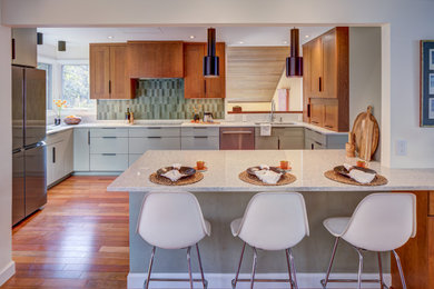 Eat-in kitchen - mid-sized contemporary u-shaped brown floor and medium tone wood floor eat-in kitchen idea in DC Metro with green backsplash, stainless steel appliances, flat-panel cabinets, quartz countertops, a peninsula, white countertops, a double-bowl sink, green cabinets and porcelain backsplash
