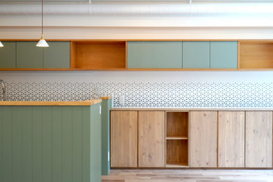 東京23区にある北欧スタイルのおしゃれなキッチン (フラットパネル扉のキャビネット、緑のキャビネット、木材カウンター、白いキッチンパネル、淡色無垢フローリング、ベージュの床、ベージュのキッチンカウンター、クロスの天井) の写真