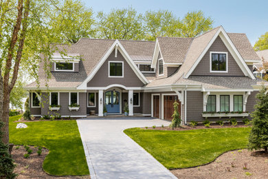 This is an example of a large traditional two-storey grey house exterior in Minneapolis with concrete fiberboard siding, a gable roof, a mixed roof, a grey roof and shingle siding.