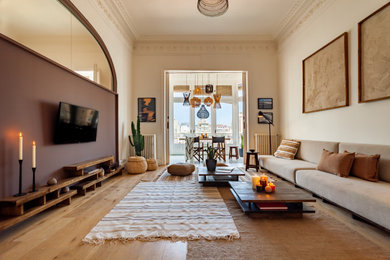 Foto de sala de estar con rincón musical abierta exótica grande con paredes marrones, suelo de madera en tonos medios y televisor colgado en la pared