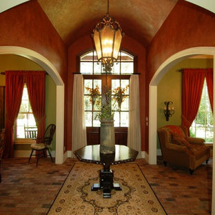 Bild på en eklektisk foajé, med flerfärgade väggar, tegelgolv, en dubbeldörr och mörk trädörr