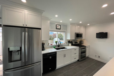 Eat-in kitchen - mid-sized modern galley porcelain tile and gray floor eat-in kitchen idea in New York with an undermount sink, shaker cabinets, white cabinets, quartz countertops, white backsplash, glass tile backsplash, stainless steel appliances, no island and white countertops