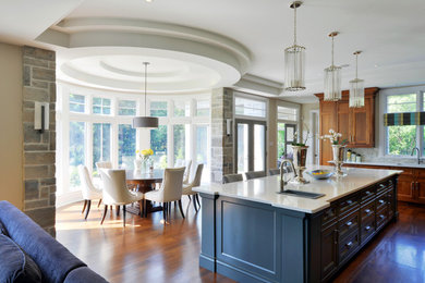 Inspiration for a transitional u-shaped medium tone wood floor open concept kitchen remodel in Toronto with a drop-in sink, recessed-panel cabinets, gray cabinets and an island