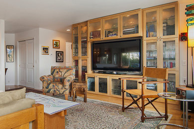 Inspiration for a large contemporary enclosed light wood floor living room library remodel in Other with white walls and a media wall