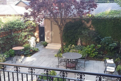 Photo of a mid-sized traditional courtyard patio in Chicago with natural stone pavers and no cover.