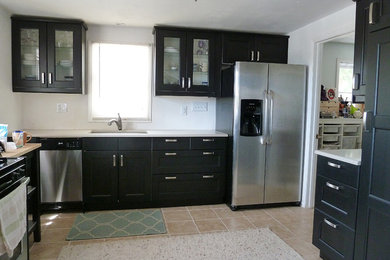 Small elegant u-shaped enclosed kitchen photo in Denver with recessed-panel cabinets, black cabinets, stainless steel appliances and no island
