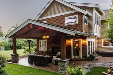 Mid-sized arts and crafts backyard stamped concrete patio photo in Seattle with a fire pit and a roof extension