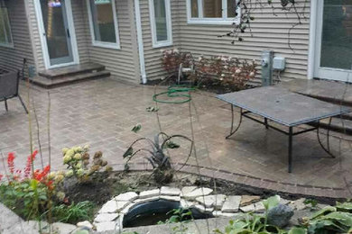 Modelo de patio clásico de tamaño medio sin cubierta en patio trasero con fuente y adoquines de ladrillo