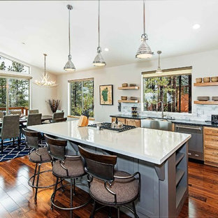 This is an example of a mid-sized contemporary single-wall kitchen pantry in Other with a farmhouse sink, light wood cabinets, quartz benchtops, grey splashback, marble splashback, stainless steel appliances, medium hardwood floors, with island, brown floor and white benchtop.