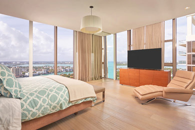 Inspiration for a contemporary bedroom in Miami with light hardwood floors and no fireplace.