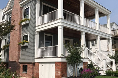 Mid-sized beach style gray three-story wood exterior home photo in Other with a shingle roof