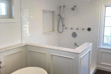 Large trendy master white tile and subway tile dark wood floor and brown floor bathroom photo in New York with white walls
