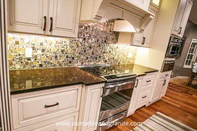 This is an example of a large kitchen with recessed-panel cabinets, white cabinets, quartz benchtops, multi-coloured splashback, mosaic tile splashback, stainless steel appliances, medium hardwood floors and with island.