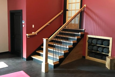 This is an example of an expansive traditional multipurpose gym in Boston with red walls, dark hardwood floors and brown floor.