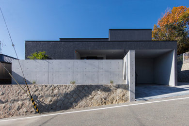 Cette photo montre une façade de maison grise moderne à un étage et de taille moyenne avec un toit en appentis.