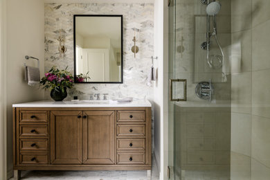 Inspiration for a transitional gray tile single-sink corner shower remodel in Seattle with recessed-panel cabinets, medium tone wood cabinets, white walls, an undermount sink, a hinged shower door, white countertops and a freestanding vanity
