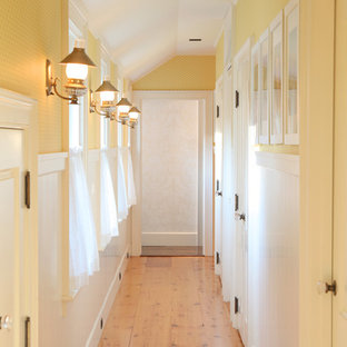 Foto på en mellanstor vintage hall, med gula väggar, ljust trägolv och beiget golv