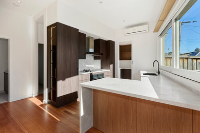 Inspiration for a large contemporary l-shaped kitchen pantry remodel in Melbourne with an island