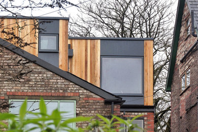 Photo of a contemporary detached house in Manchester with wood cladding.