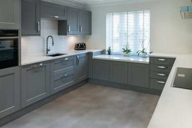 This is an example of a large contemporary u-shaped eat-in kitchen in Kent with shaker cabinets, grey cabinets, quartzite benchtops and white benchtop.
