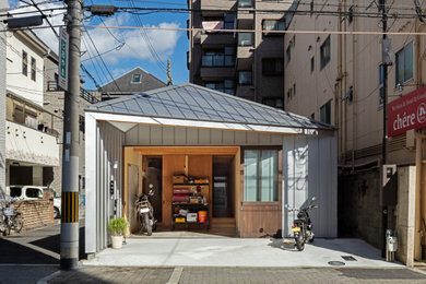 Photo of a small industrial hallway in Osaka with grey walls, a sliding front door, a dark wood front door, grey floors, a drop ceiling and panelled walls.