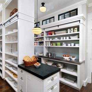 Große Klassische Küche in L-Form mit weißen Schränken, dunklem Holzboden, Landhausspüle, Schrankfronten mit vertiefter Füllung, Granit-Arbeitsplatte, Küchenrückwand in Weiß, Rückwand aus Metrofliesen, schwarzen Elektrogeräten, Kücheninsel, Vorratsschrank und braunem Boden in San Francisco