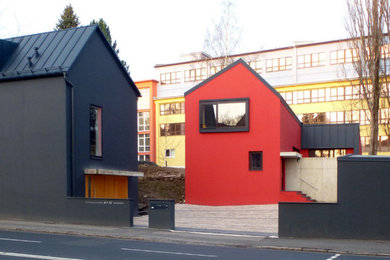 Einfamilienhaus mit roter Fassadenfarbe, Satteldach und Blechdach in Sonstige