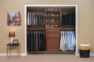 Inspiration for a small men's carpeted reach-in closet remodel in New York with recessed-panel cabinets and medium tone wood cabinets