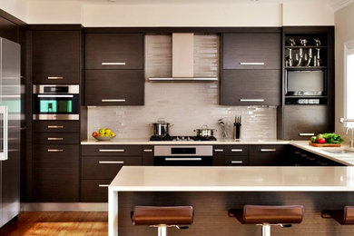 Mid-sized trendy u-shaped medium tone wood floor and brown floor eat-in kitchen photo in Toronto with an undermount sink, flat-panel cabinets, dark wood cabinets, quartz countertops, beige backsplash, ceramic backsplash, stainless steel appliances, a peninsula and brown countertops