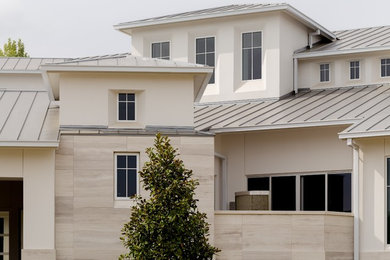 Inspiration for a large contemporary white two-story stucco house exterior remodel in Houston with a metal roof