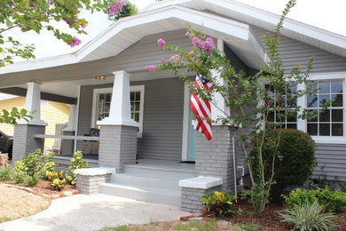 Ejemplo de fachada de casa gris de estilo americano de dos plantas con revestimiento de vinilo y tejado de teja de madera