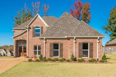 Inspiration for a timeless two-story brick exterior home remodel in Other with a hip roof