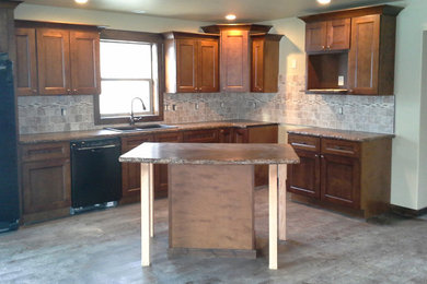 Mid-sized mountain style l-shaped dark wood floor open concept kitchen photo in Other with a double-bowl sink, shaker cabinets, dark wood cabinets, concrete countertops, brown backsplash, ceramic backsplash, black appliances and an island