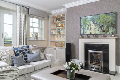 Photo of a contemporary living room in Surrey with grey walls, carpet, a standard fireplace, a stone fireplace surround, a wall-mounted tv and grey floor.