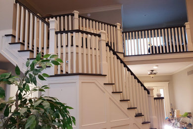 Modelo de escalera en L clásica grande con escalones de madera, contrahuellas de madera, barandilla de madera y boiserie
